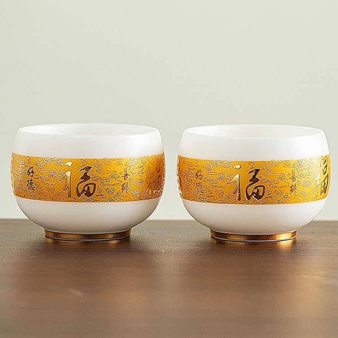 Traditional Chinese mutton-fat jade teacups, decorated with gold leaf patterns; white ceramic teacups with gilded interiors; and handcrafted tea bowls. (FU - white)