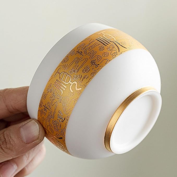 Traditional Chinese mutton-fat jade teacups, decorated with gold leaf patterns; white ceramic teacups with gilded interiors; and handcrafted tea bowls. (FU - white)
