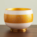 Traditional Chinese mutton-fat jade teacups, decorated with gold leaf patterns; white ceramic teacups with gilded interiors; and handcrafted tea bowls. (SHUN - Gold)