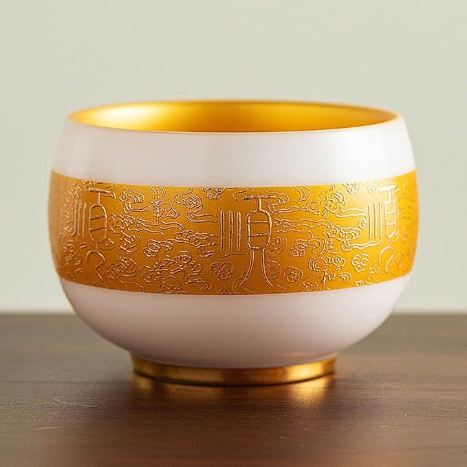 Traditional Chinese mutton-fat jade teacups, decorated with gold leaf patterns; white ceramic teacups with gilded interiors; and handcrafted tea bowls. (SHUN - Gold)