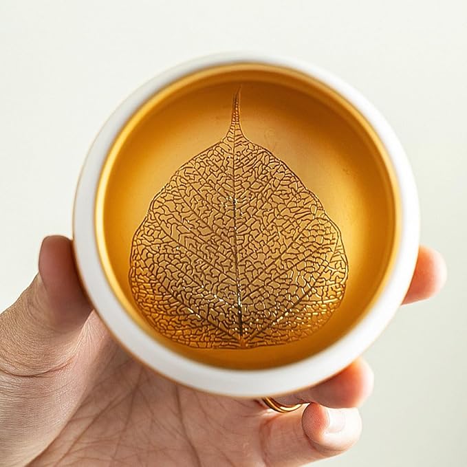 Traditional Chinese mutton-fat jade teacups, decorated with gold leaf patterns; white ceramic teacups with gilded interiors; and handcrafted tea bowls. (FU - Gold)