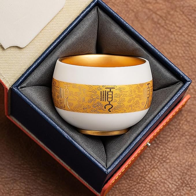 Traditional Chinese mutton-fat jade teacups, decorated with gold leaf patterns; white ceramic teacups with gilded interiors; and handcrafted tea bowls. (SHUN - Gold)