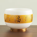 Traditional Chinese mutton-fat jade teacups, decorated with gold leaf patterns; white ceramic teacups with gilded interiors; and handcrafted tea bowls. (FU - white)