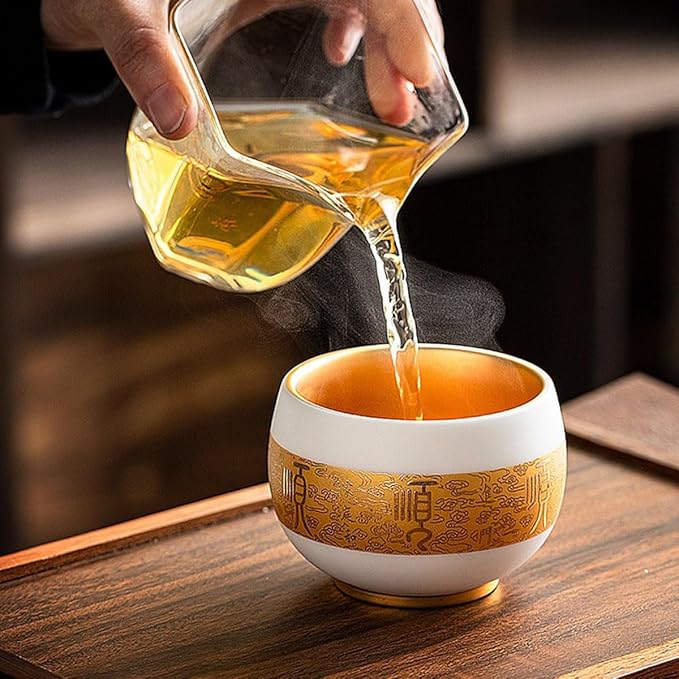 Traditional Chinese mutton-fat jade teacups, decorated with gold leaf patterns; white ceramic teacups with gilded interiors; and handcrafted tea bowls. (FU - Gold)